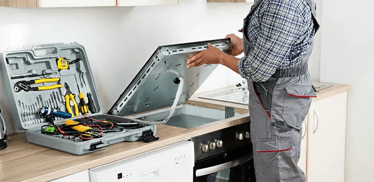Handyman repairing a cooktop and checking wiring connections in Pittsburgh, PA