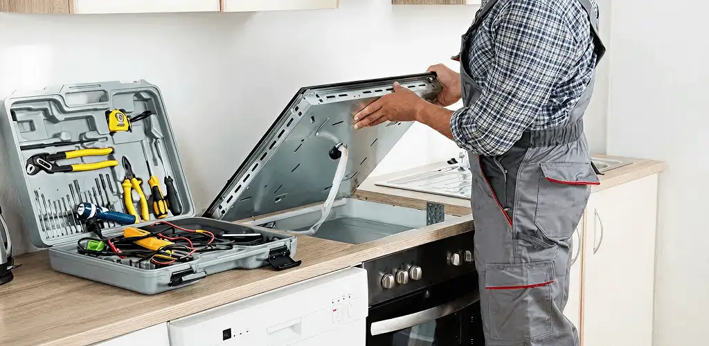 Handyman repairing a cooktop and checking wiring connections in Pittsburgh, PA