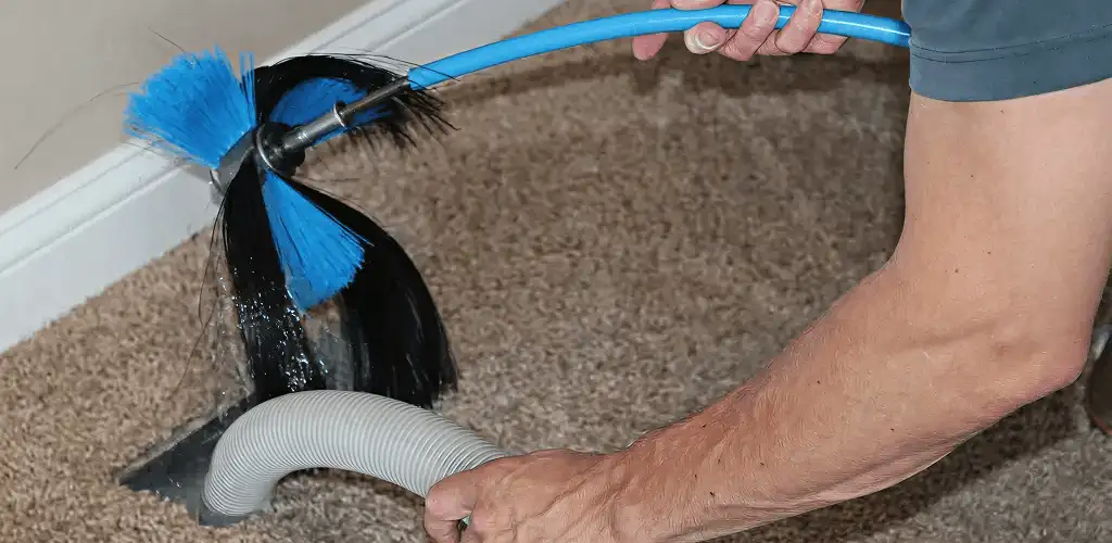 Dryer vent cleaning technician brushing lint from a vent line in Pittsburgh, PA