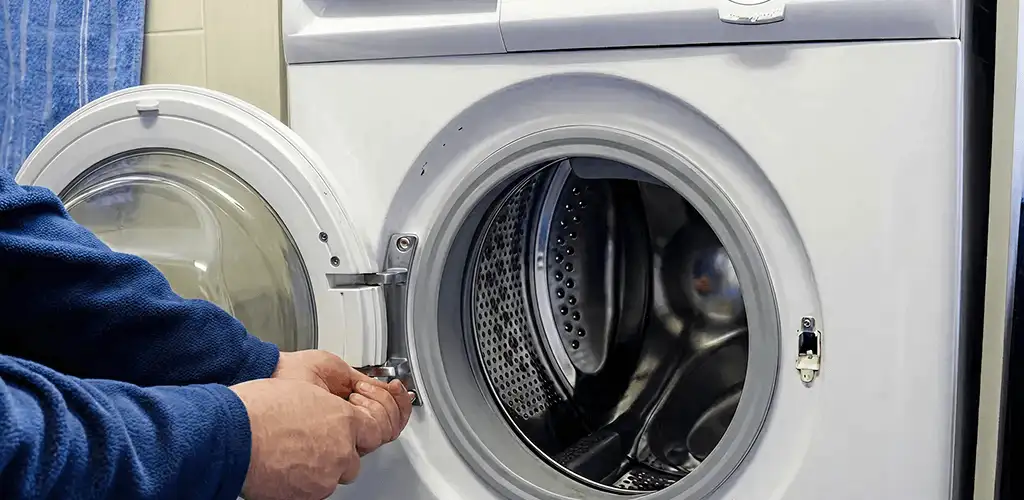 Washing machine repair handyman checking a front-load washer door and latch in Pittsburgh, PA