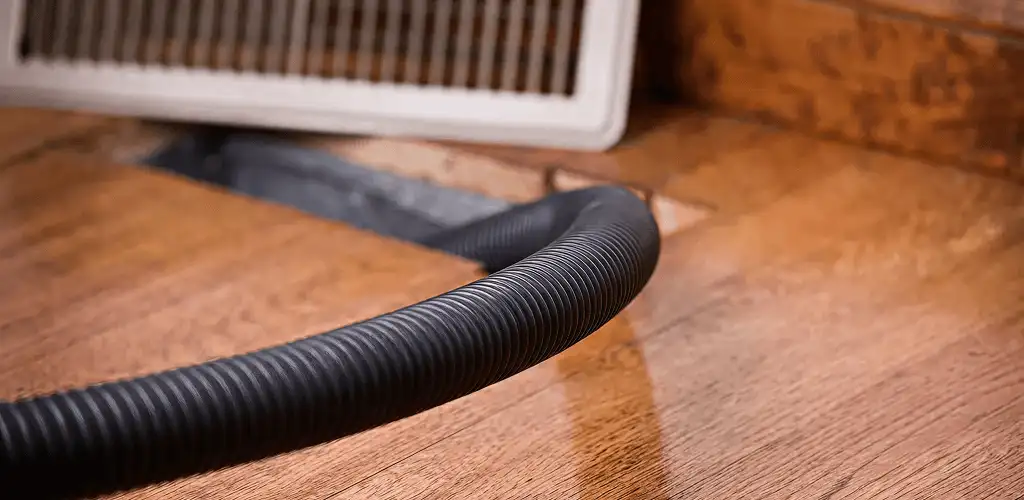 Air duct cleaning hose inserted into a floor vent for ductwork cleaning in Pittsburgh, PA