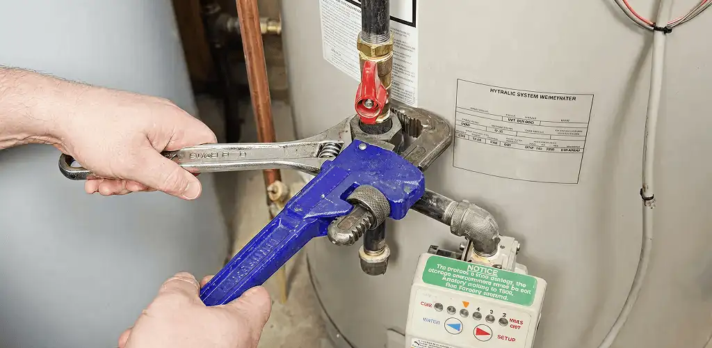 Water heater repair technician tightening the shutoff valve and supply line in Pittsburgh, PA